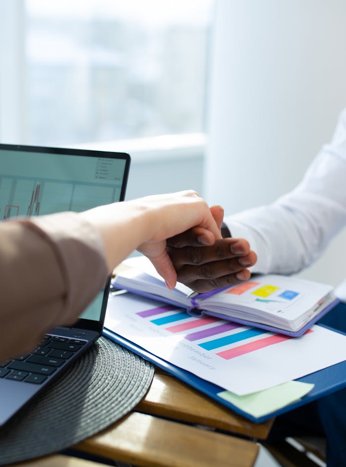 Office colleagues engaging in a handshake during a productive meeting, showcasing teamwork and collaboration.